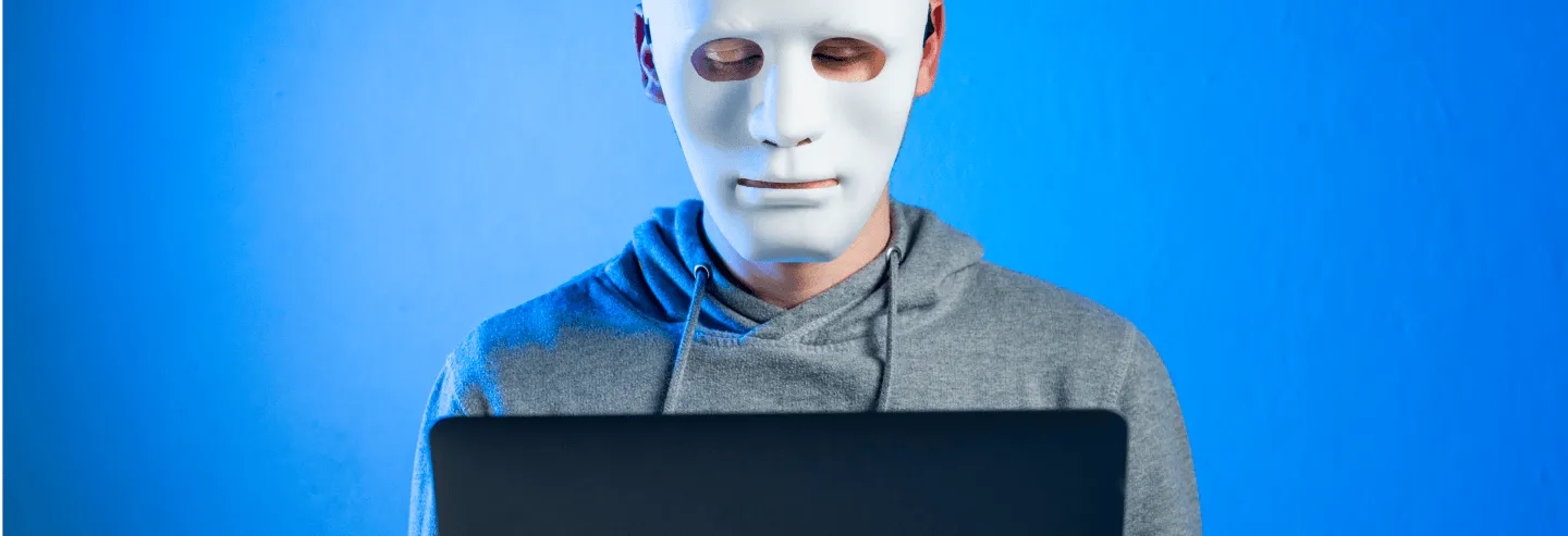 man wearing a mask holding laptop